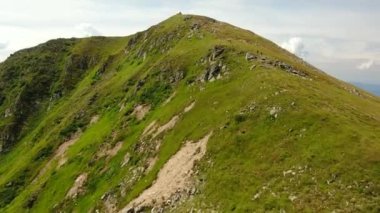 Dağın tepesine yakın bir yerden insansız hava aracı vuruldu. Kamera ileri ve aşağı doğru eğiliyor. 