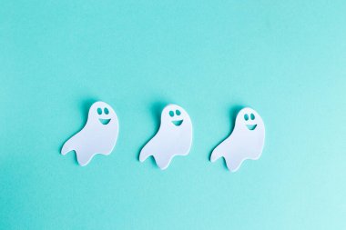 Halloween decorations white ghosts on turquoise background