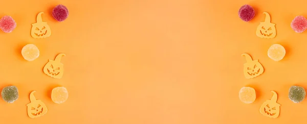 Cadılar Bayramı süslemeleri, balkabakları, şekerler, turuncu arka planda. Cadılar Bayramı partisi tebrik kartı. Uzayı kopyala Düz yatıyordu, üstten, yukarıdan..