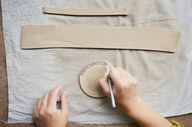 Çömlek atölyesinde çalışan kadın seramik. Seramikçinin Elleri Kirli Çamur. Çömlek yapma süreci. Usta seramist onun stüdyosunda çalışıyor.