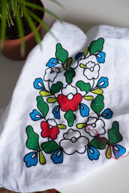 Renkli çiçek işlemeli beyaz keten kumaş. Geleneksel Ukrayna nakışı