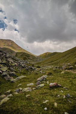 Gürcistan 'daki Kazbek Dağı' na kayalık arazi ve bulutlu gökyüzü ile tırmanmak