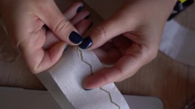 Öğleden sonra ışığında masada otururken basit bir kurdele dizaynını elle dikmek. Geleneksel Ukrayna Nakışı