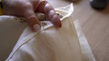 Ev çalışma alanında el aletleriyle kumaşa nasıl dikiş atılacağı konusunda dersler veriyorum. Geleneksel Ukrayna Nakışı