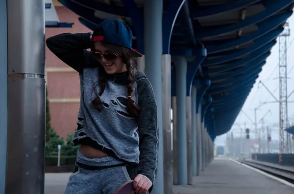 Belle fille hipster avec planche à roulettes portant des lunettes de soleil — Photo