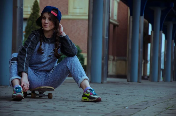 Vacker hipster flicka med skate board bär solglasögon — Stockfoto