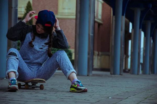 Schönes Hipster-Mädchen mit Skateboard und Sonnenbrille — Stockfoto