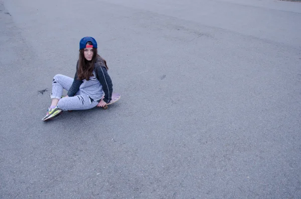 Menina hipster bonita com skate bordo usando óculos de sol — Fotografia de Stock