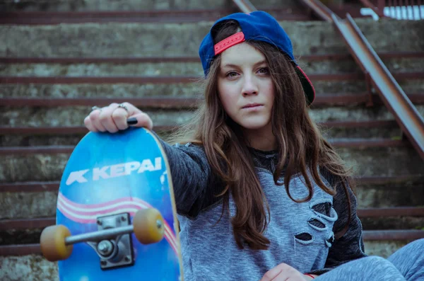 Vacker hipster flicka med skate board bär solglasögon — Stockfoto