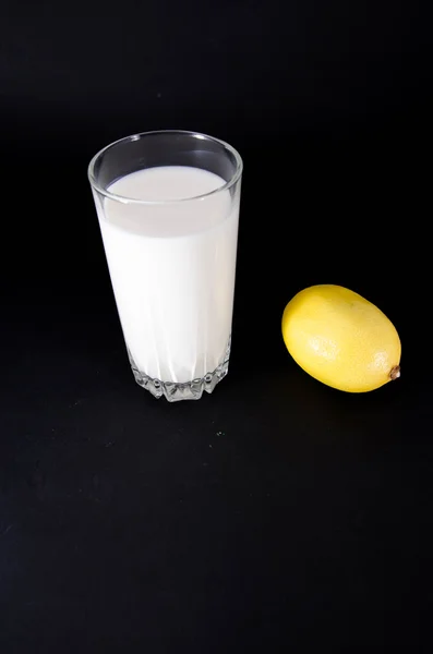 Glass of milk and lemon — Stock Photo, Image