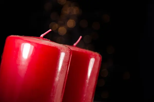 Vela roja con fuego contra luces desenfocadas — Foto de Stock