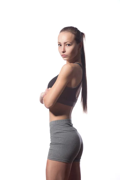 Mulher fitness em estilo esporte de pé contra fundo branco — Fotografia de Stock