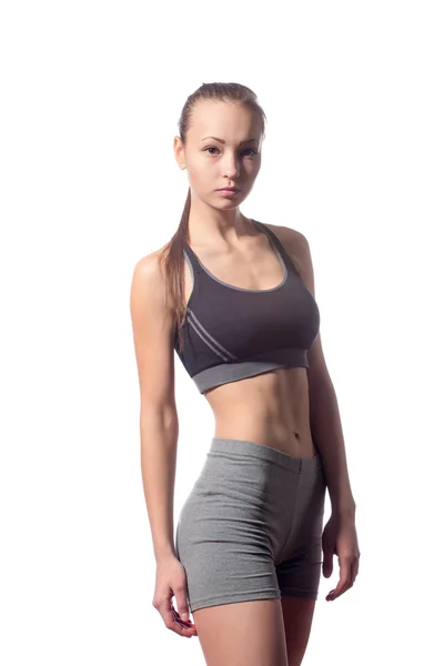 Mulher fitness em estilo esporte de pé contra fundo branco — Fotografia de Stock