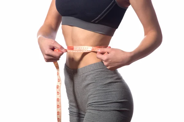 Beyaz bir arka plan kasette ölçme ile çekici fitness modeli