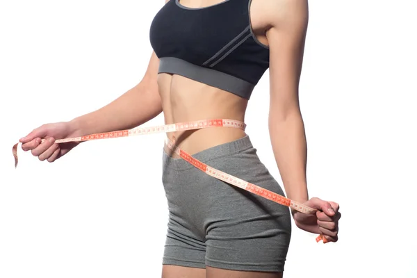 Beyaz bir arka plan kasette ölçme ile çekici fitness modeli