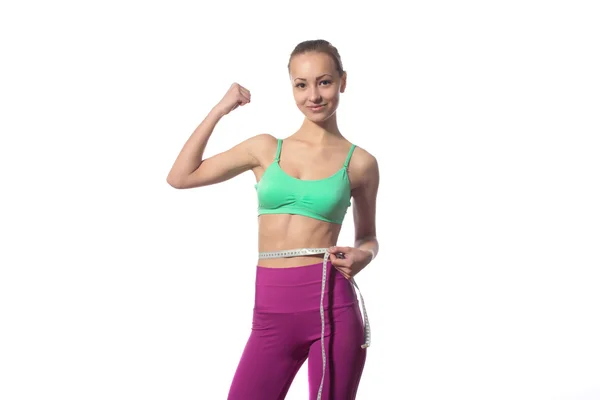 Aantrekkelijke fitness model met het meetlint op een witte achtergrond — Stockfoto