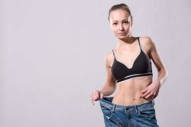 Kız onu kilo kaybı bir eski kot giyerek gösterir