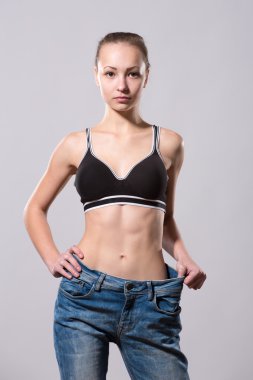 Kız onu kilo kaybı bir eski kot giyerek gösterir