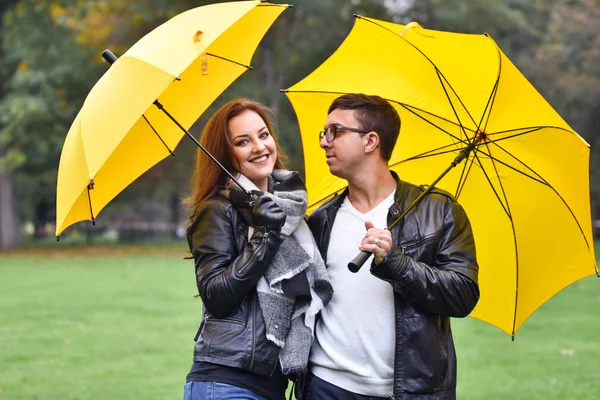 Pareja joven en otoño con un paraguas — Foto de Stock