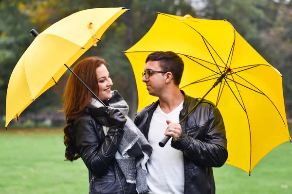 Pareja joven en otoño con un paraguas — Foto de Stock