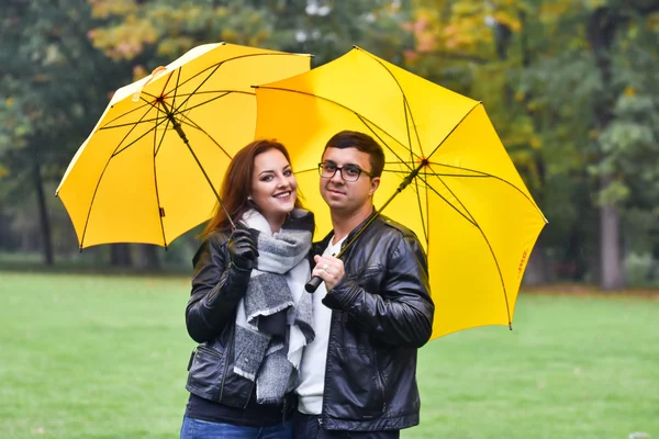 Młoda para na jesieni z parasolem — Zdjęcie stockowe