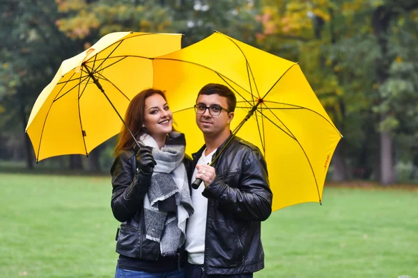 Νεαρό ζευγάρι το φθινόπωρο με μια ομπρέλα — Φωτογραφία Αρχείου