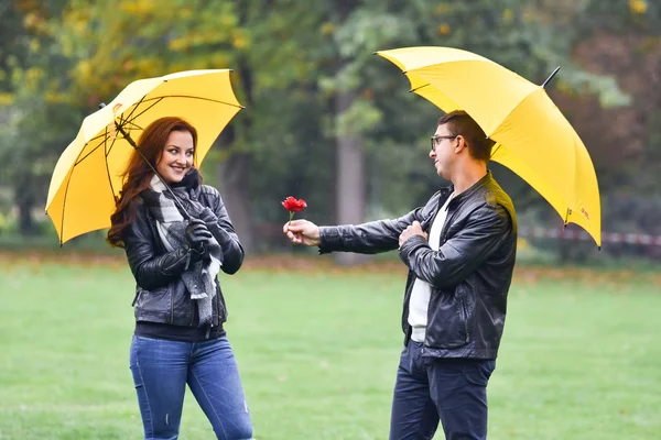 Pareja joven en otoño con un paraguas — Foto de Stock