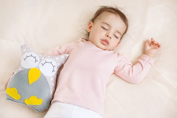 Αξιολάτρευτο ύπνο κορίτσι μωρό παιδί στο κρεβάτι με μια κουκουβάγια παιχνίδι — Φωτογραφία Αρχείου