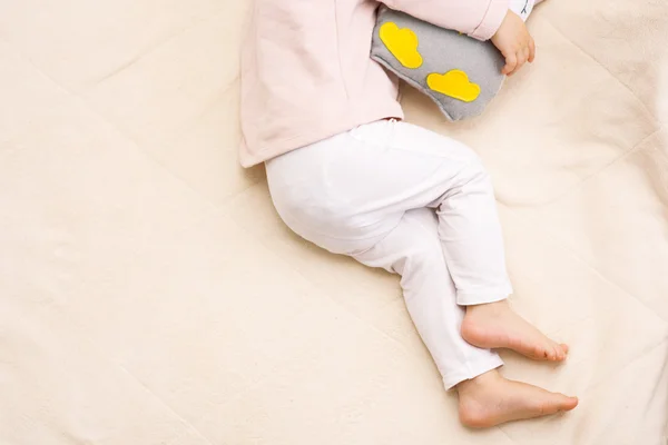 Little beautiful legs of a baby girl toddler sleeping with a owl toy — Stock Photo, Image