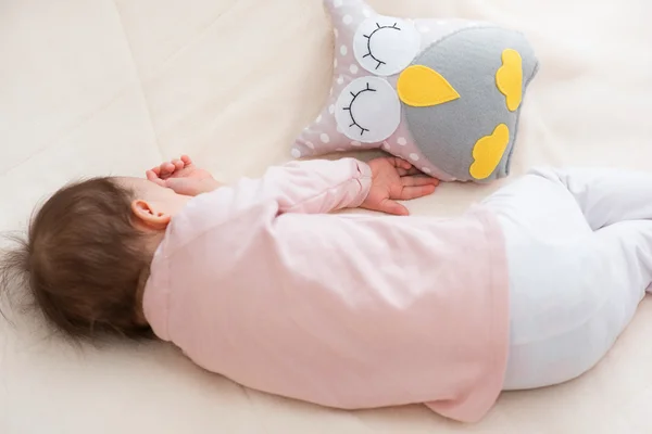 Στον ύπνο πίσω μωρό παιδί κορίτσι με μια κουκουβάγια παιχνίδι στο κρεβάτι — Φωτογραφία Αρχείου