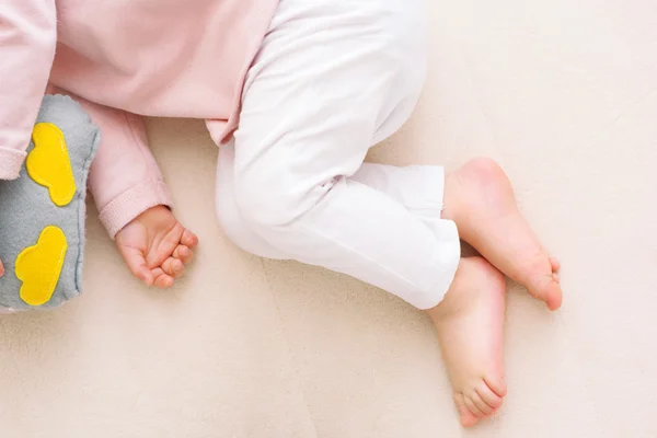 Очаровательные маленькие ножки малышки спят с совиной игрушкой — стоковое фото