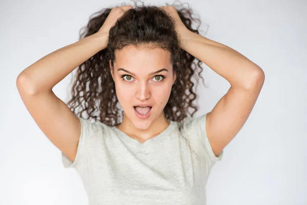 Překvapený mladá žena s shromážděné kudrnaté vlasy a přisunou — Stock fotografie