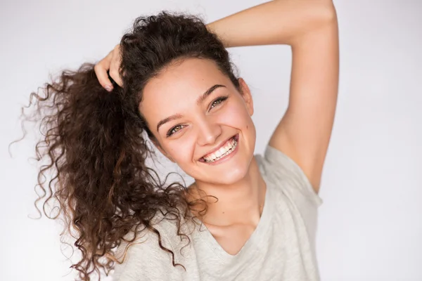 Happy and beautiful face of young brunette woman smiling with curly hair. Close-up portrait Royalty Free Stock Images