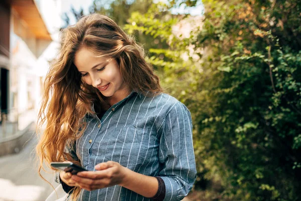 Mavi Tişörtlü Gülümseyen Bir Kadın Cep Telefonundan Mesaj Atıyor Güzel — Stok fotoğraf