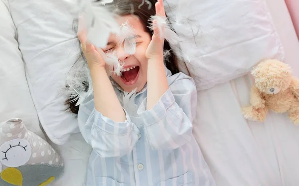 Вид Сверху Кавказскую Веселую Маленькую Девочку Играющую Белыми Перьями Лежащую — стоковое фото