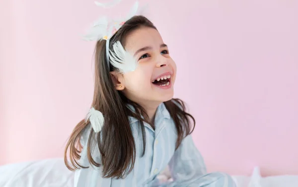 Ένα Χαρούμενο Κοριτσάκι Στην Πιτζάμα Απολαμβάνει Κομφετί Από Λευκά Φτερά — Φωτογραφία Αρχείου
