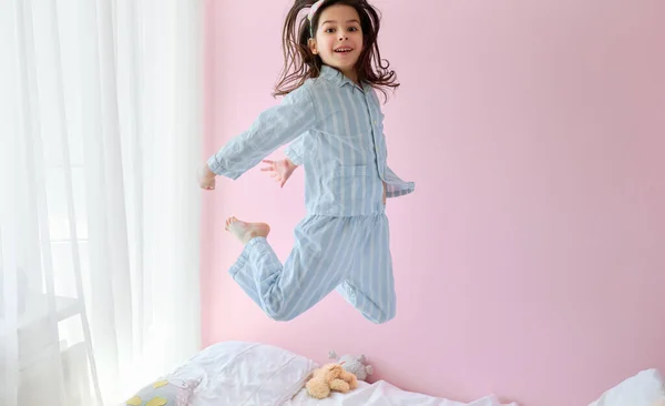 Горизонтальное Изображение Счастливой Маленькой Девочки Голубой Пижаме Прыгающей Современной Уютной — стоковое фото