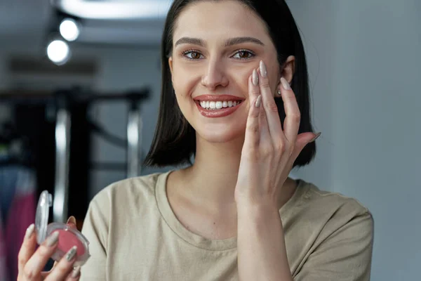 Retrato Uma Fêmea Sorrindo Aplicando Creme Seu Rosto Morena Jovem — Fotografia de Stock