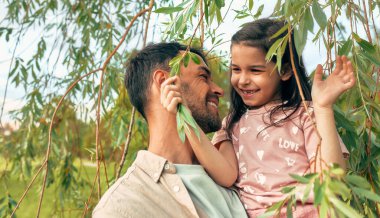 Neşeli baba parkta küçük tatlı kızıyla oynuyor..