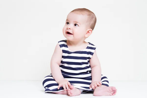 Bonito sorrindo bonito bebê menina sentado e olhando algo — Fotografia de Stock