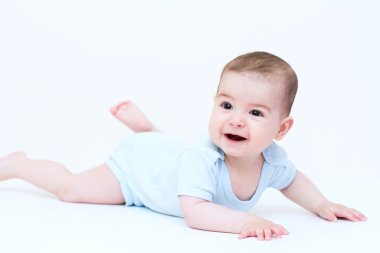 Beyaz yerde yatarken gülümseyen şirin bebek