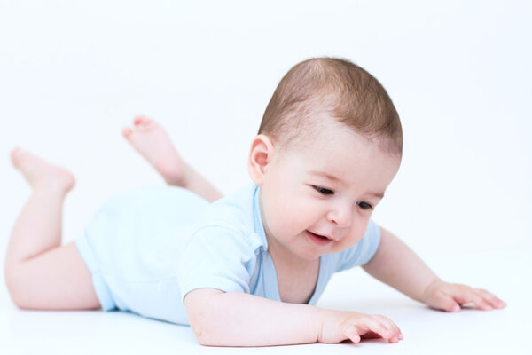 Улыбающийся ребенок смотрит вниз на белом фоне
