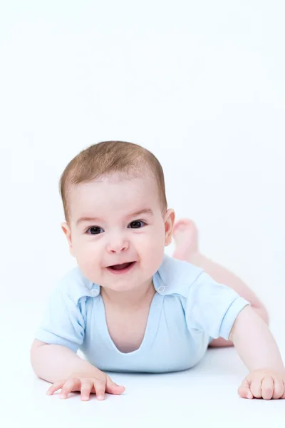 Uśmiechający się ładny dziecka leżącego na podłodze biały — Zdjęcie stockowe