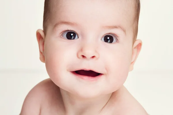 Zbliżenie portret piękne dziecko patrzeć na aparat i uśmiechając się — Zdjęcie stockowe