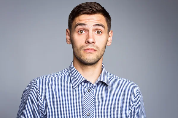 Rostro sorprendido del hombre de negocios sobre fondo gris — Foto de Stock