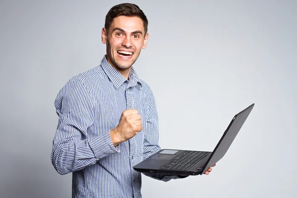 Retrato de homem de negócios com um laptop em um fundo cinza — Fotografia de Stock