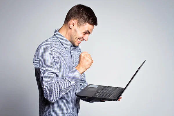 Retrato de homem de negócios com um laptop em um fundo cinza — Fotografia de Stock