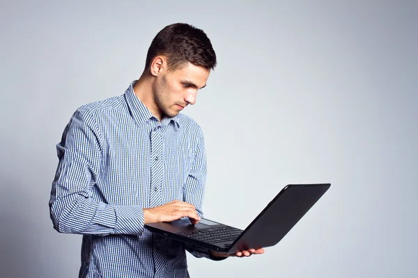 Retrato de homem de negócios com um laptop em um fundo cinza — Fotografia de Stock