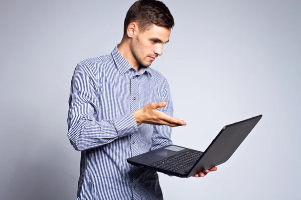 Retrato de homem de negócios com um laptop em um fundo cinza — Fotografia de Stock