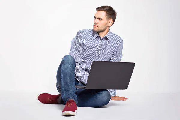 Homem de negócios com um laptop em um fundo branco — Fotografia de Stock